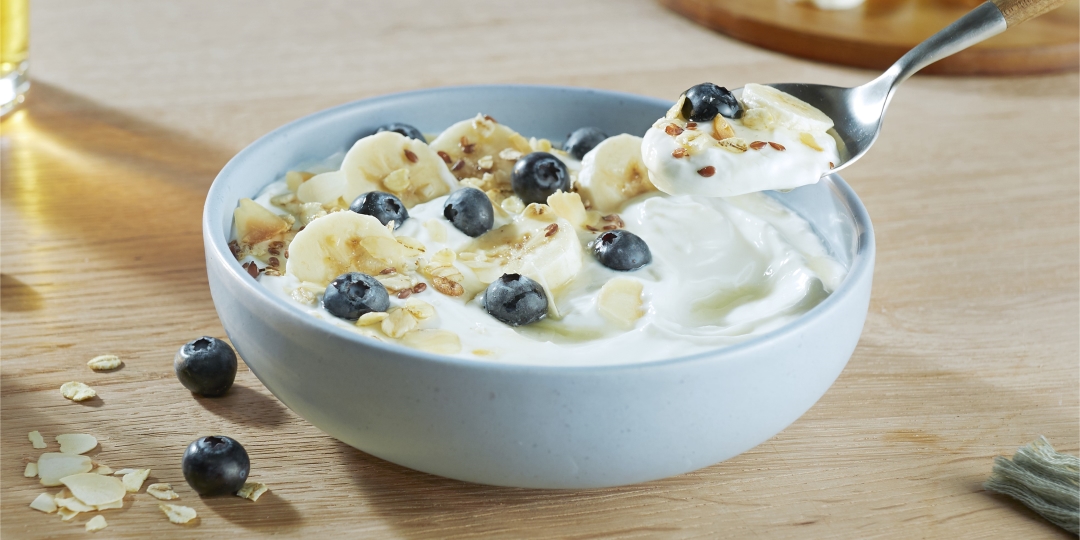 Griekse yoghurt met honing, banaan, blauwe bessen en lijnzaad